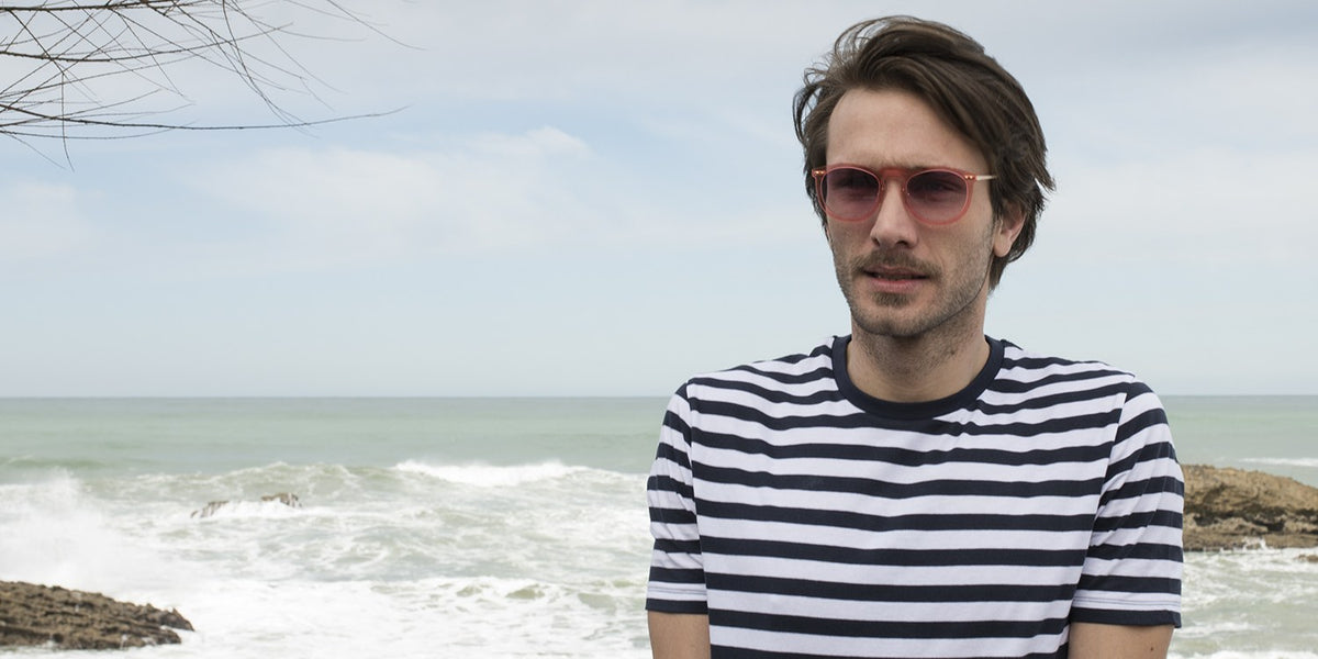 Man wearing round Sunpers Biarritz sunglasses by the sea